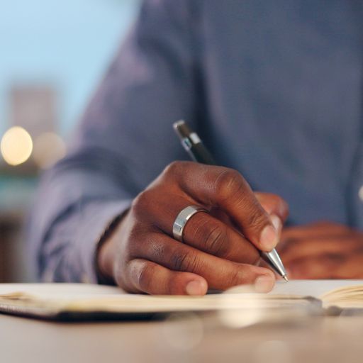 smiling-couple-looking-at-notebook-while-sitting